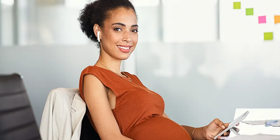 A pregnant worker at her desk